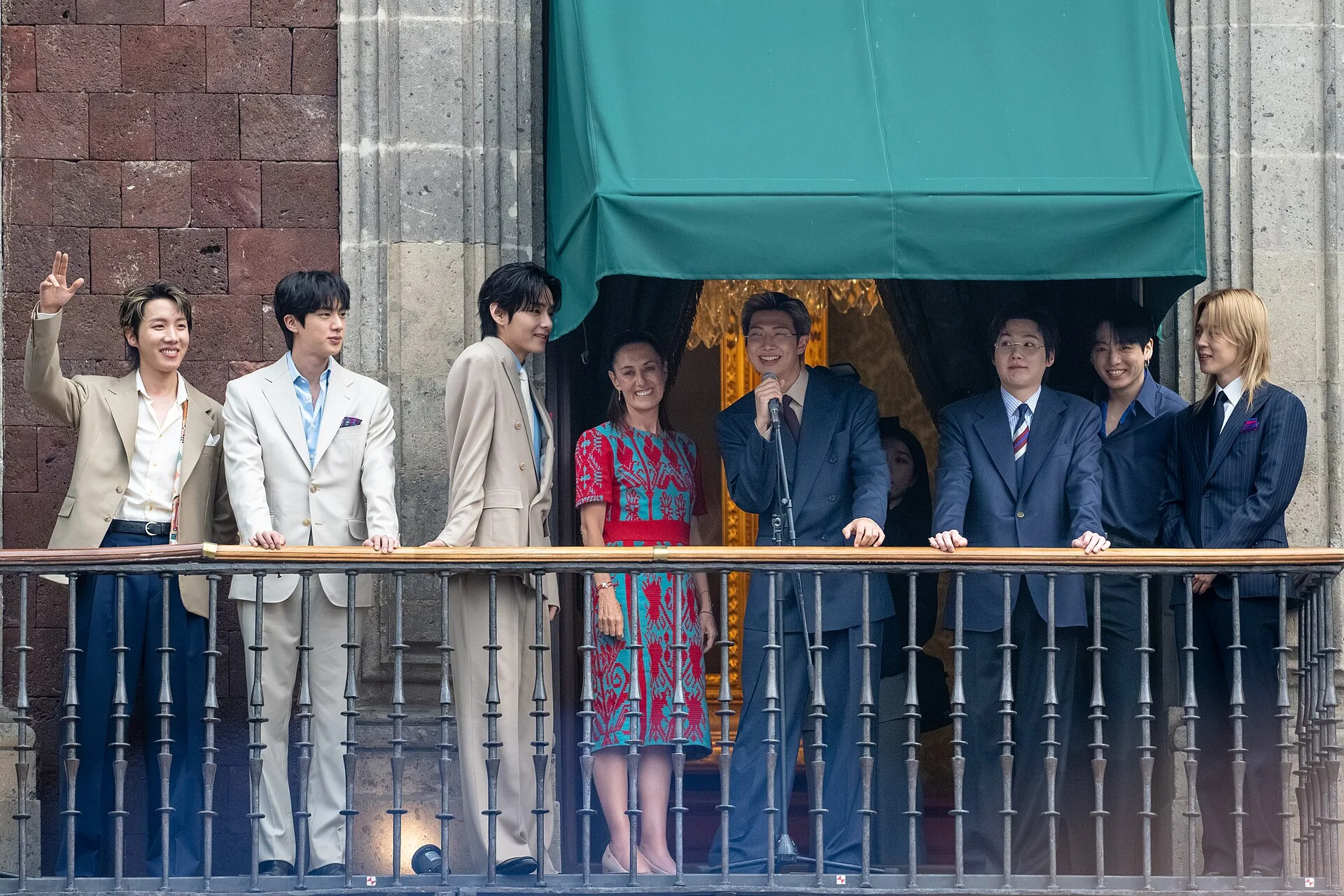 The seven members of BTS standing with Mexican President Claudia Sheinbaum at the National Palace in May 2026