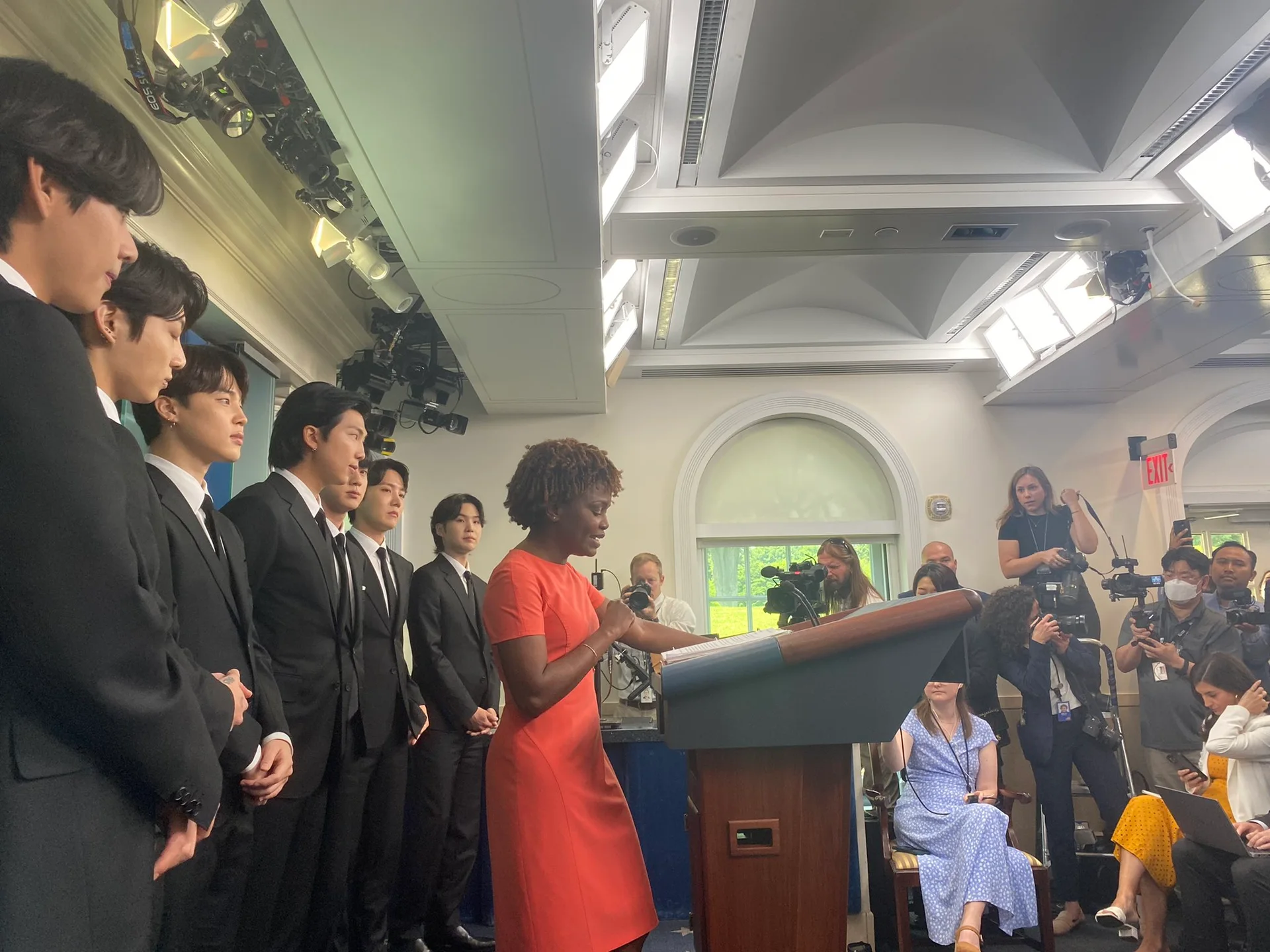 BTS standing with Karine Jean-Pierre in the White House press briefing room on May 31, 2022