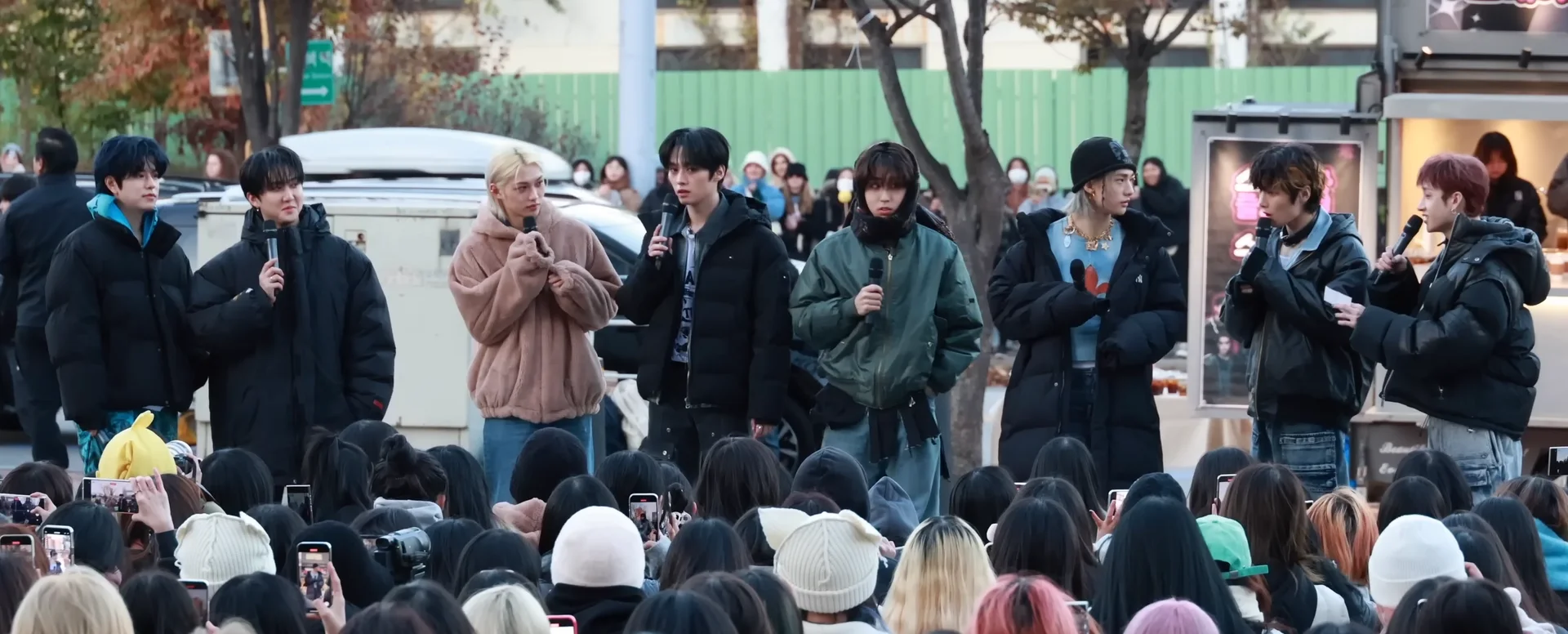 Eight Stray Kids members speaking to fans at a Music Core mini fan meeting in November 2023